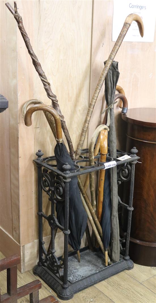 A cast iron stick stand and umbrellas etc. W.43cm